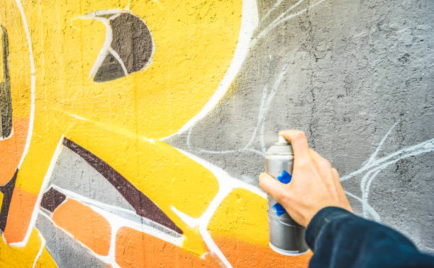 detalle de calle artista pintar graffiti colorido en el filtro de pared pública - concepto de arte moderno con chico urbano dibujo vivo murales con spray de aerosol de color multi - vintage con énfasis en pintura amarilla - graffiti men wall street art fotografías e imágenes de stock