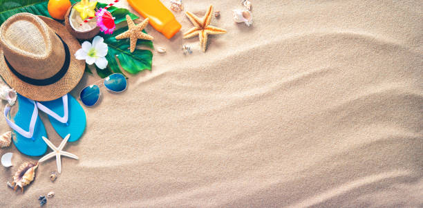 Straw hat with a exotic cocktail and sunglasses on sand beach