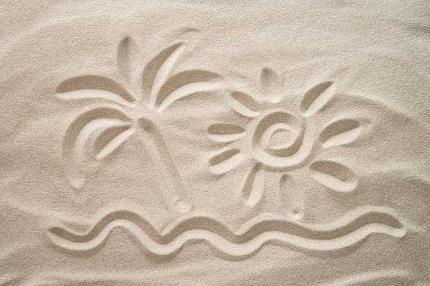 Sun, palm and sea hand-drawn on the beach sand. Beach holiday concept