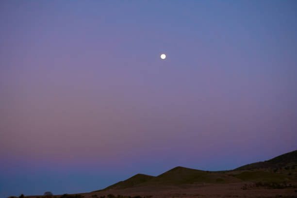 istock Landscape hills view with little full moon at the evening multicolored sky. 984139440