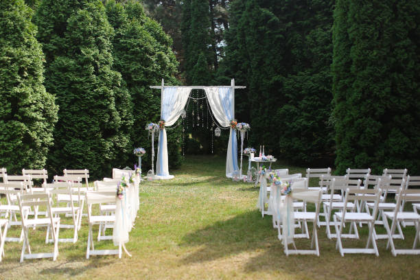 istock White wedding arch in park and decorated chairs 984173752
