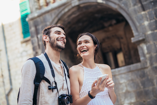 Viajar a pareja de turistas caminando por el casco antiguo y usando el teléfono inteligente photo