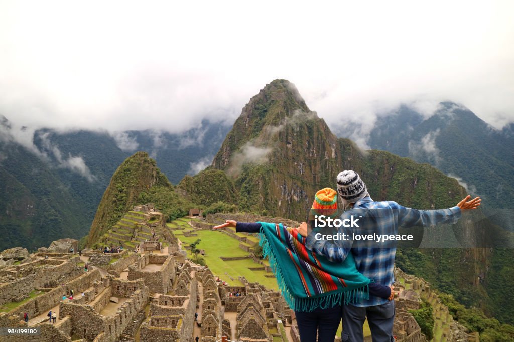 Couple admiring the spectacular view of Machu Picchu, Cusco Region, Urubamba Province, Peru, Archaeological site, UNESCO World Heritage Travel Stock Photo