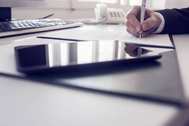 istock Businessman writing at a desk in a low angle view 984228684