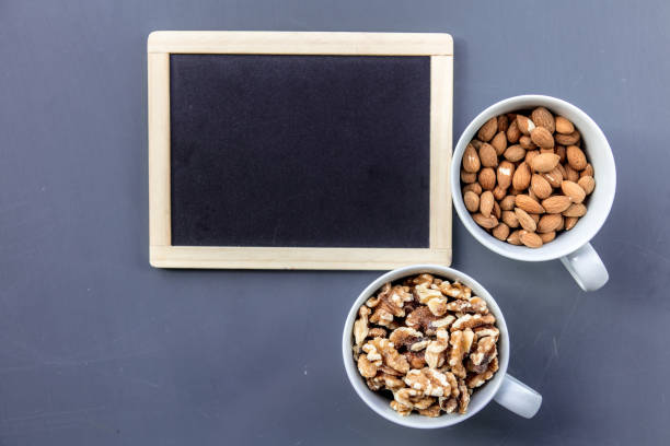 istock White cups full of almonds and walnuts 984258594