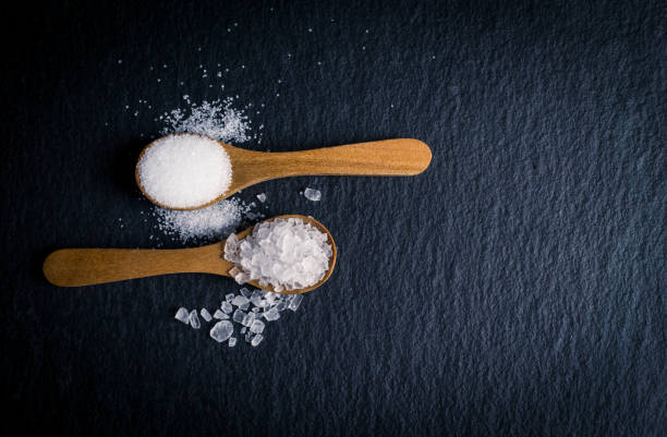 istock Different types of salt. Top view on two wooden spoons 984259844