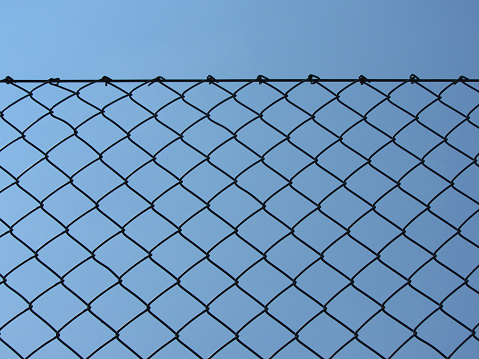 Wire fence against the clear blue sky.