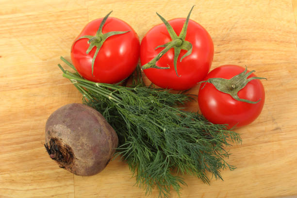 istock Beetroot, three ripe tomatoes and bunch of the fresh dill leaves on a cutting board 984271548