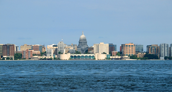 Cloudy blue sky over downtown with capitol state building and Monona terrace. Summer view across the lake Monona. City of Madison, the capital of Wisconsin, Midwest USA.