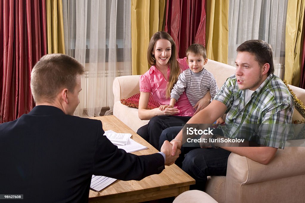 Happy family meeting with agent at home  Adult Stock Photo