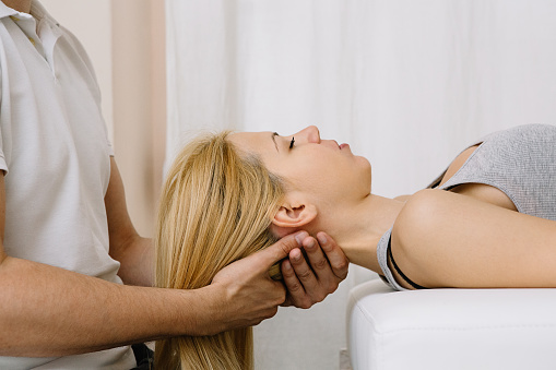 Physiotherapist using chiropractic techniques for neck adjustments
