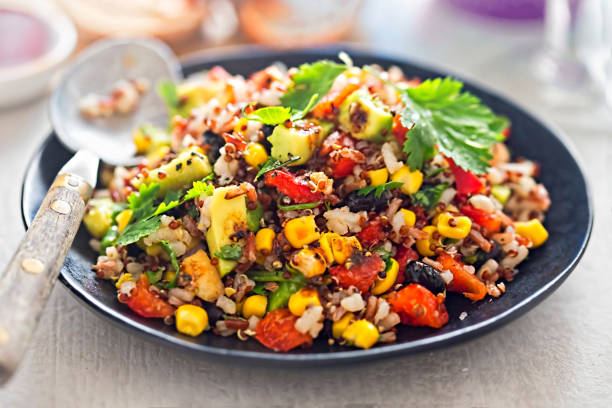 Black beans, avocado, corn, tomato, rice & quinoa salad with chilli dressing stock photo