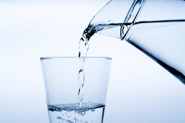 istock Close up pouring drinking water into glass, studio shot 984313664