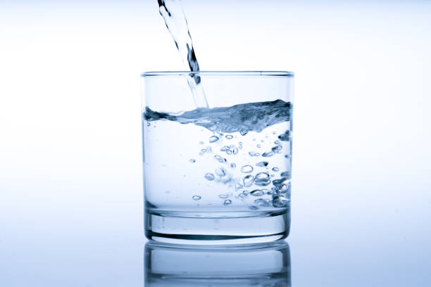 istock Close up pouring drinking water into glass, studio shot 984313700