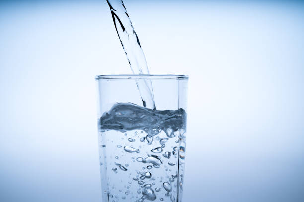 istock Close up pouring drinking water into glass, studio shot 984313714