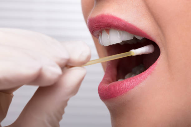 Dentist's Hand Taking Saliva Test From Woman's Mouth Dentist's Hand Taking Saliva Test From Woman's Mouth With Cotton Swab cotton swab stock pictures, royalty-free photos & images