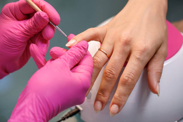 istock beautician applying Polish nails 984324608