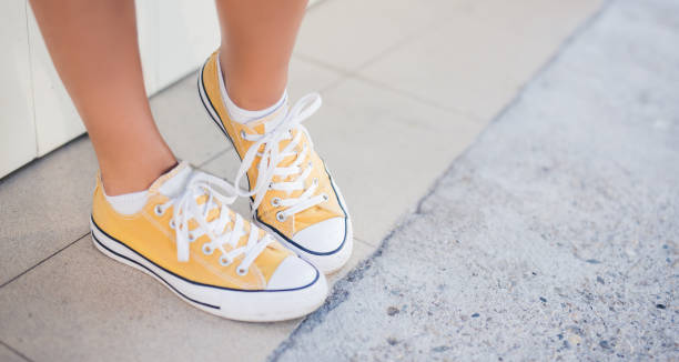 istock Yellow sneakers on girl legs 984338228