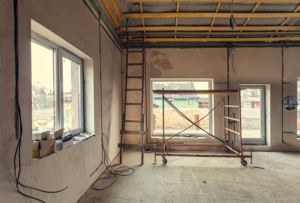 istock Working process of warming inside part of roof with using erecting stage in  apartment is under construction, remodeling, renovation, extension, restoration. overhaul and reconstruction. 984351354