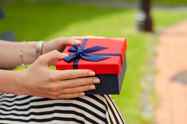 istock A woman is holding a gift box in hand 984357892