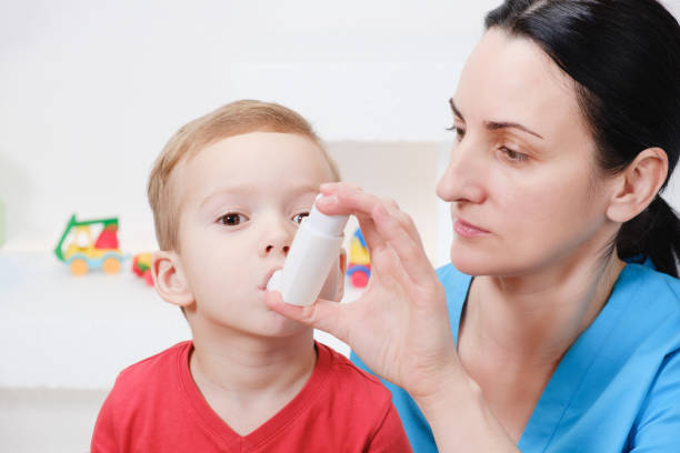 causian kleiner junge inhalation mit vernebler im krankenhaus machen. - asthmatic child asthma inhaler inhaling stock-fotos und bilder