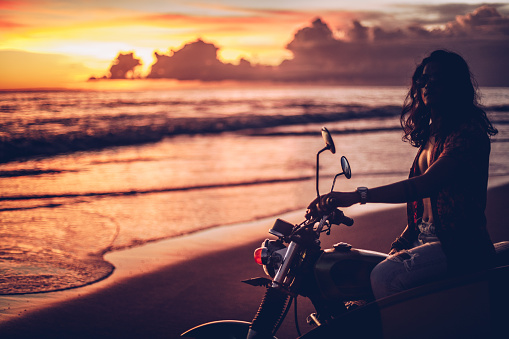 Surfer on a motorcycle at the beach