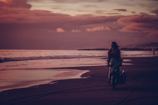 istock Man riding motorcycle at the beach 984364324
