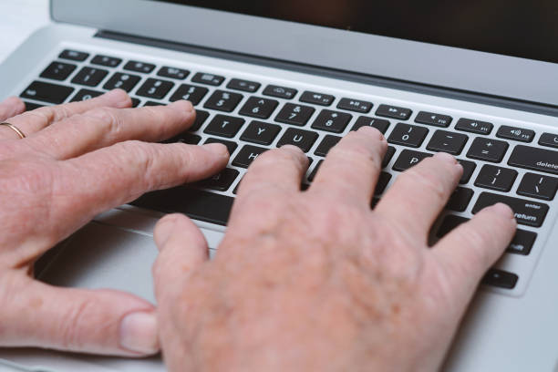 istock Close up view of senior hands with laptop 984368890