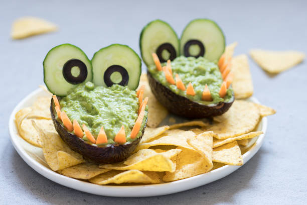 istock Funny alligator avocado guacamole dip and nachos 984384270