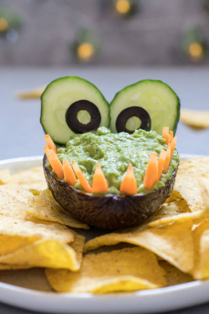 istock Funny alligator avocado guacamole dip and nachos 984386348
