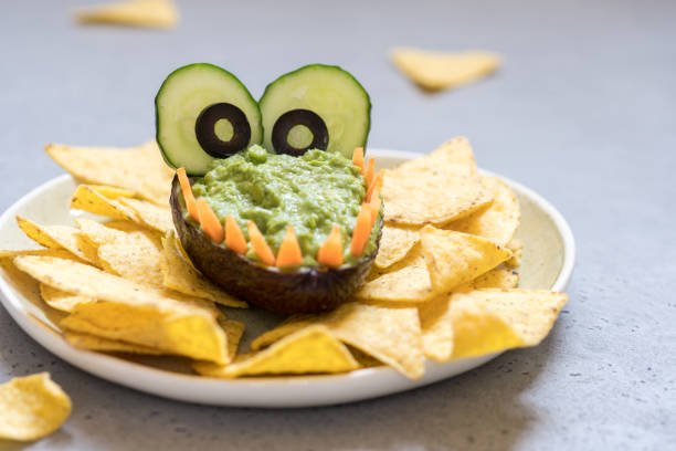istock Funny alligator avocado guacamole dip and nachos 984386452