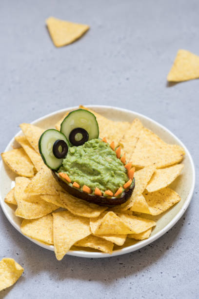 istock Funny alligator avocado guacamole dip and nachos 984386516