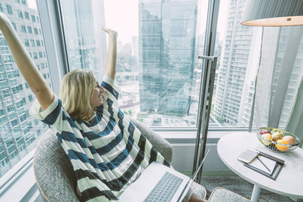istock Successful woman using computer in hotel room, business travel 984394648