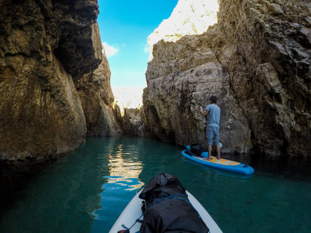 istock Man on SUP paddling into a canyon on sea 984412428