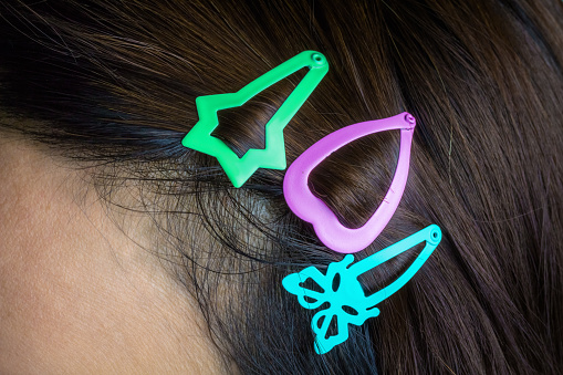 Colored hair clips that are attached to a woman's hair.