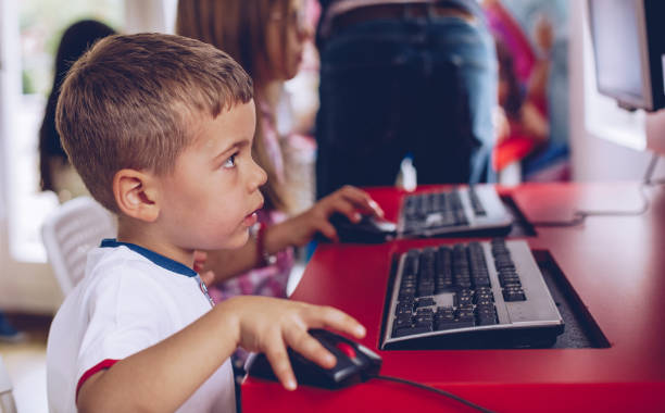 profesor ayudar a los niños usando computadoras - computer lab child internet development fotografías e imágenes de stock