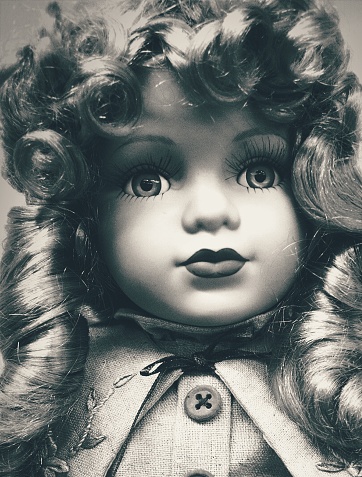 Faded photograph of a curly haired doll