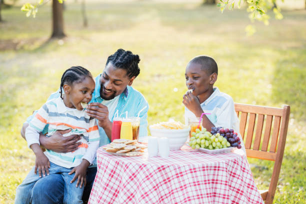 istock Father, two boys at cookout, eating potato chips 984459470