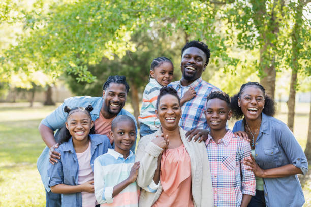 Large African-American family reunion A large African-American family with aunts, uncles and cousins, standing together, smiling for a family portrait, outdoors at the park or in the back yard. family reunion stock pictures, royalty-free photos & images