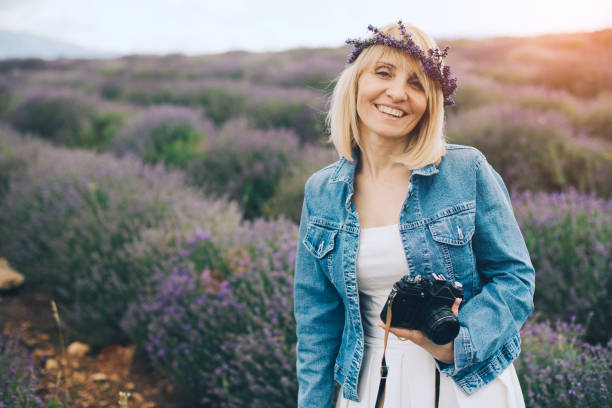 Beautiful mature blond in lavender field, sunny day positive emotions , flowers in her hair