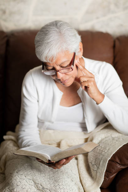 istock Senior woman reading book and thinking 984475716