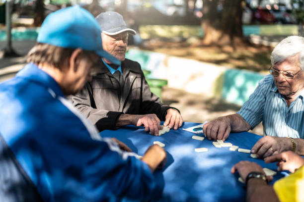 istock Active Retirement Old Friends Playing Domino Game 984477500