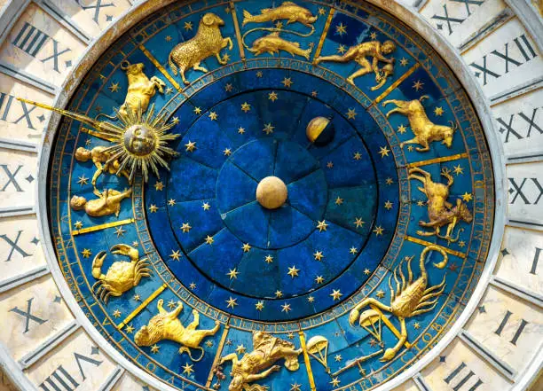 Ancient clock Torre dell'Orologio on St Mark's Square (San Marco) in Venice. Detail with clock face and astrological Zodiac signs. Vintage dial close-up, medieval art of Italy. Astrology concept.