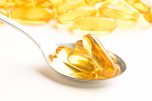 istock fish oil capsules in a spoon on white background 984507490