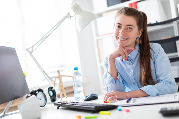 istock Young girl in the office sits at the computer desk. 984518742