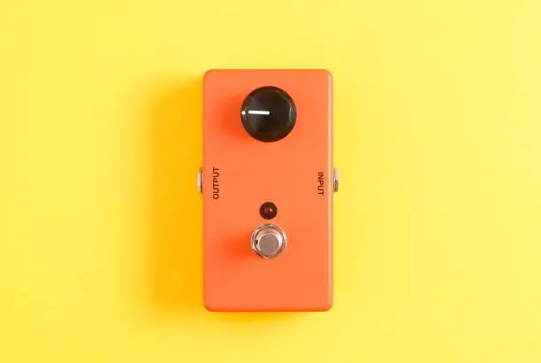 Orange guitar stompbox on yellow background