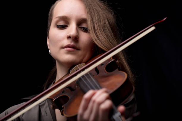 istock passionate violin musician playing on black background 984555004