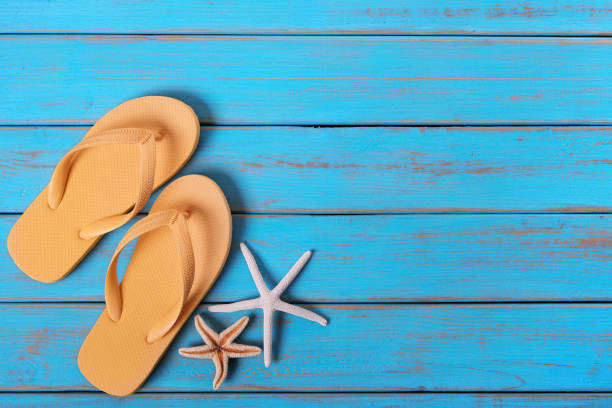 istock Flip flops starfish old distressed bright blue beach wood 984572454