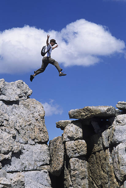 istock Man Leaping a gap of rocks 98460662