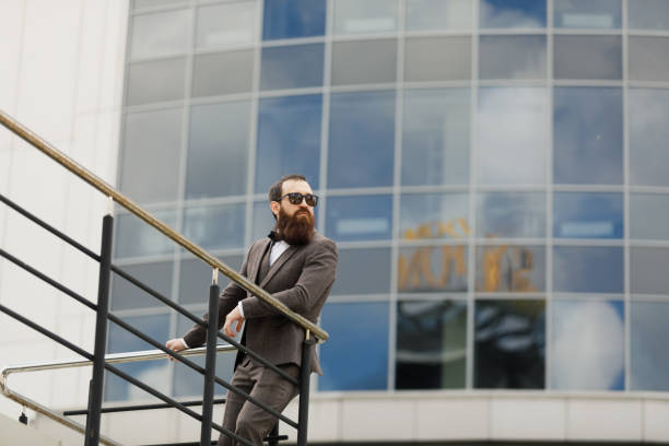istock Modern businessman. Confident young man in full suit looking away while standing outdoors with cityscape in the background 984607080